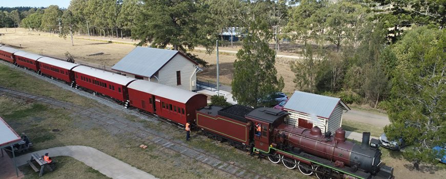 Mary Valley Rattler C17 974 and heritage carriages at Amamoor Station from the air-web